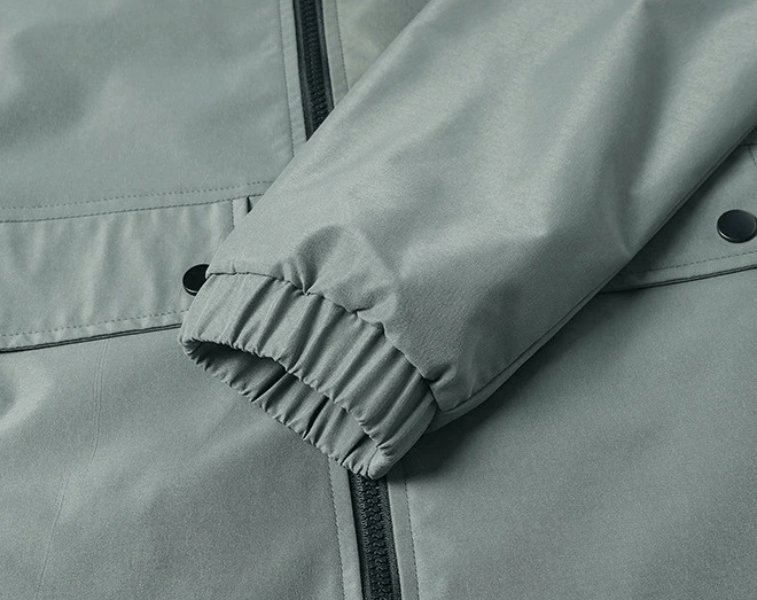 Close-up of Slim Men's Sporty Jacket with zipper closure and rib cuffs, featuring durable polyester fabric and large pockets for functionality.
